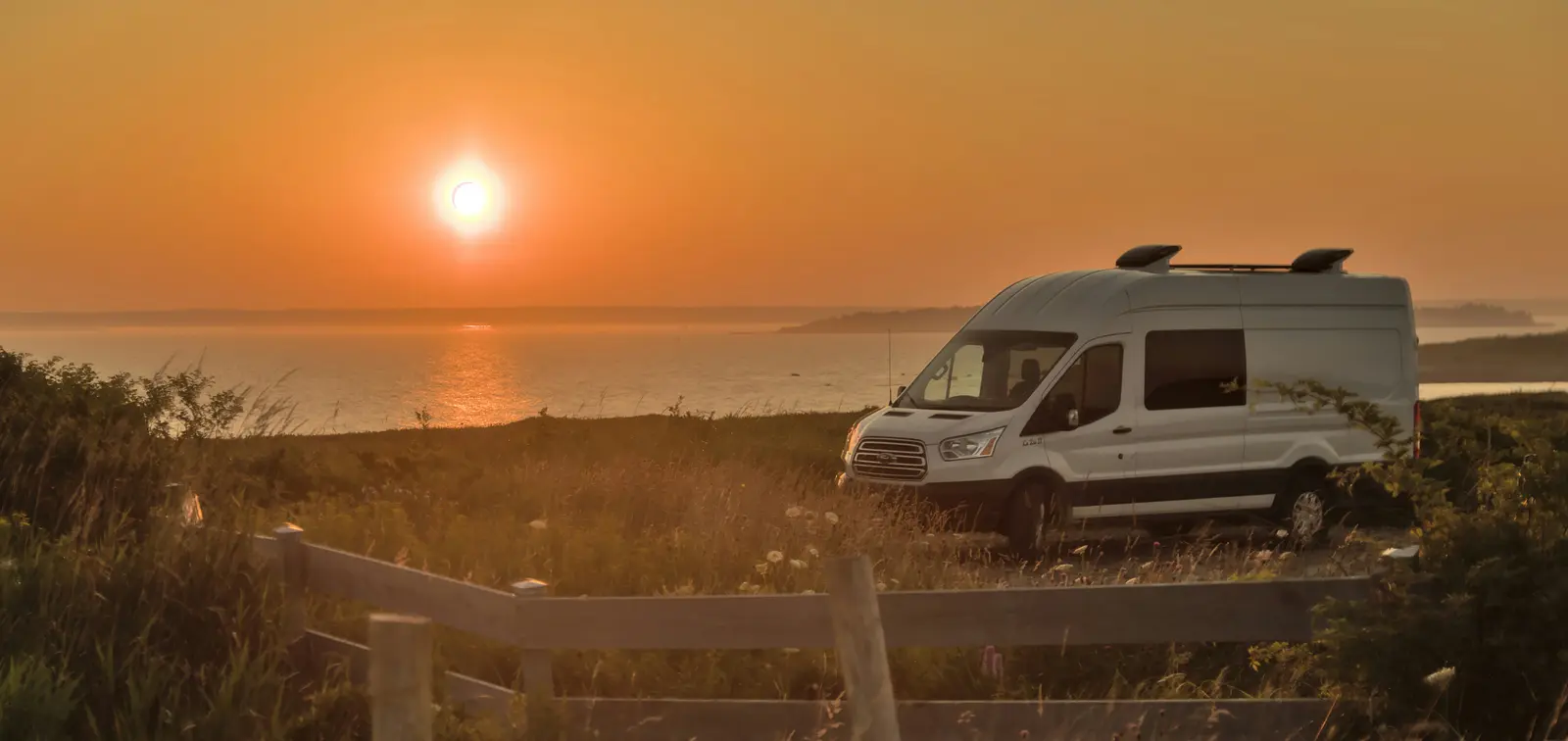 Camper van at sunset by the coast